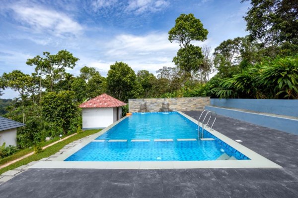 Luxury Munnar Resorts With Private Pool featuring a stunning infinity pool, modern hillside accommodation, and breathtaking valley views at a Private Pool Resort In Munnar, one of the finest Resorts In Munnar With Pool.